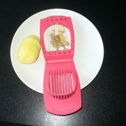 Pellkartoffeln in Scheiben schneiden und gleichzeitig pellen