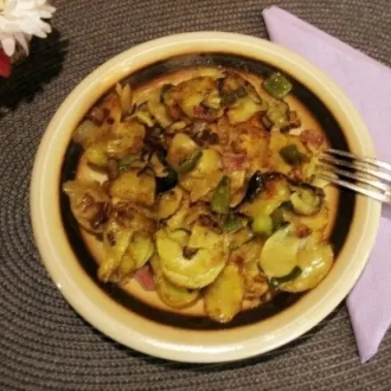 Gebratene Zucchini- und Kartoffelscheiben mit Bacon