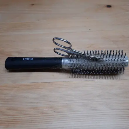 Haare aus der Rundbürste mit Nagelschere entfernen