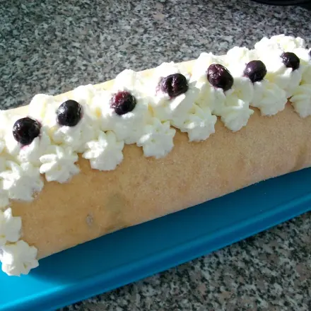 Biskuitrolle mit Sahne und Heidelbeeren
