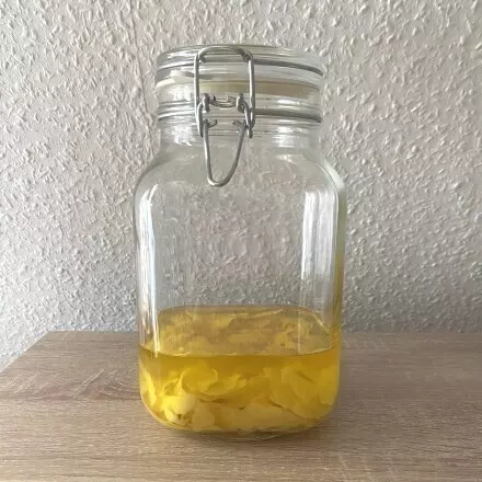 Nach mindestens einer Woche Ruhezeit haben die Zitronenschale einiges an Farbe verloren und der Alkohol ist wunderbar gelb.