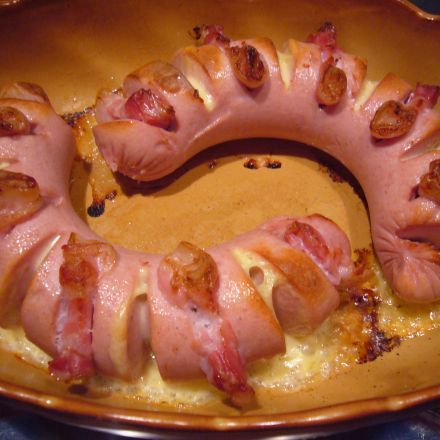 Fleischwurst mit rohem Schinken und Käse überbacken