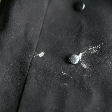 Angetrocknete Flecken auf dunklem Stoff wegrubbeln