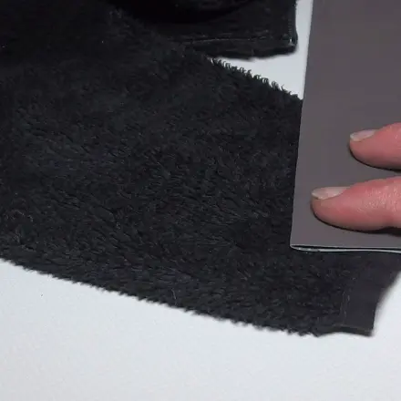 Glänzende Stoffe mit Sandpapier behandeln