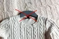 Pullover und Sweatshirt auf den Kleiderbügel hängen