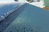 Gefrorene Autoscheibe mit lauwarmem Wasser enteisen