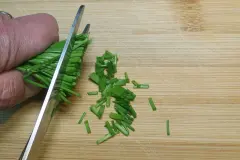 Schnittlauch mit der Schere schneiden